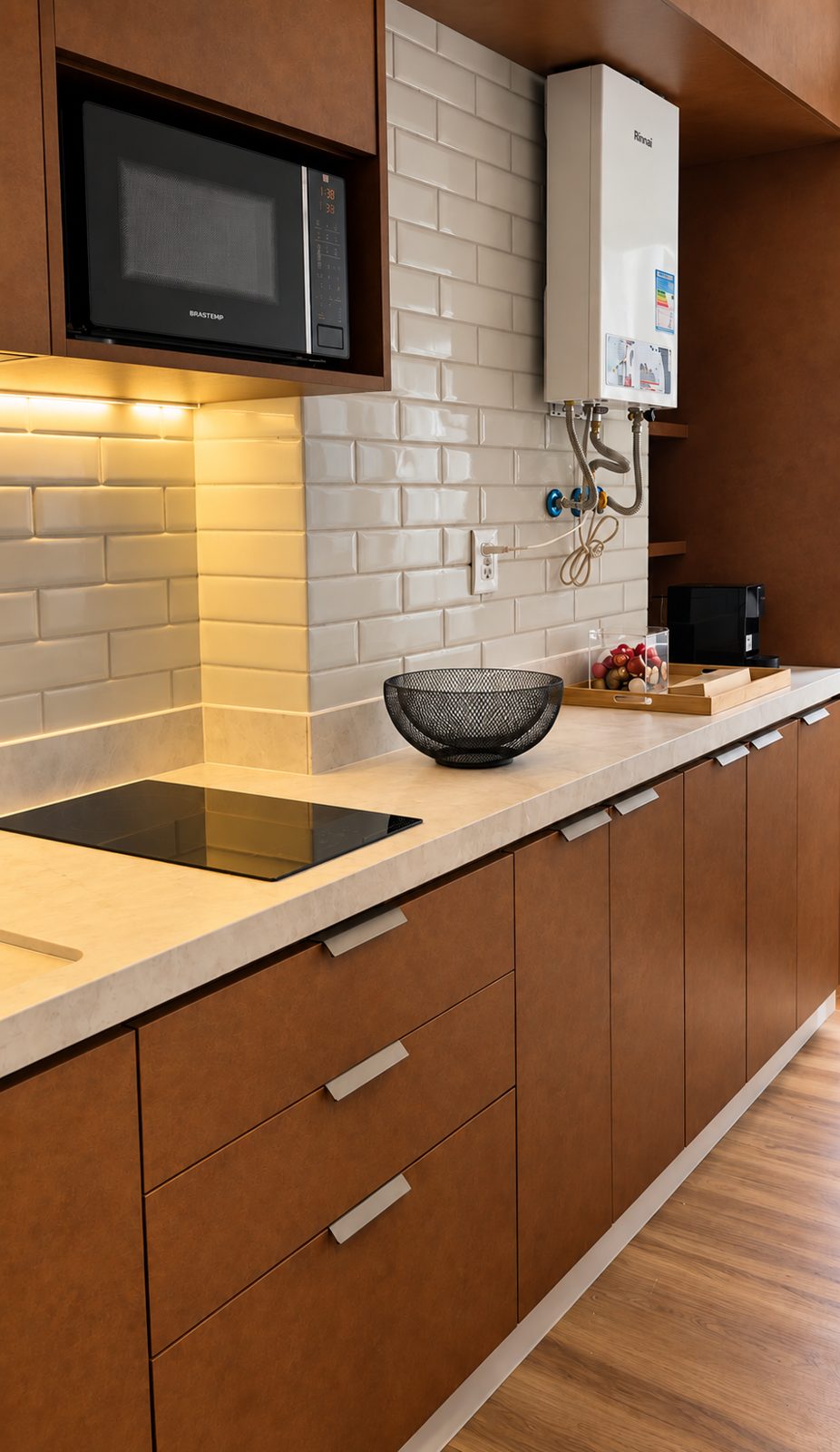 Frente de cocina con nicho para microondas, placa de inducción, revestimiento biselado y luz bajo los muebles