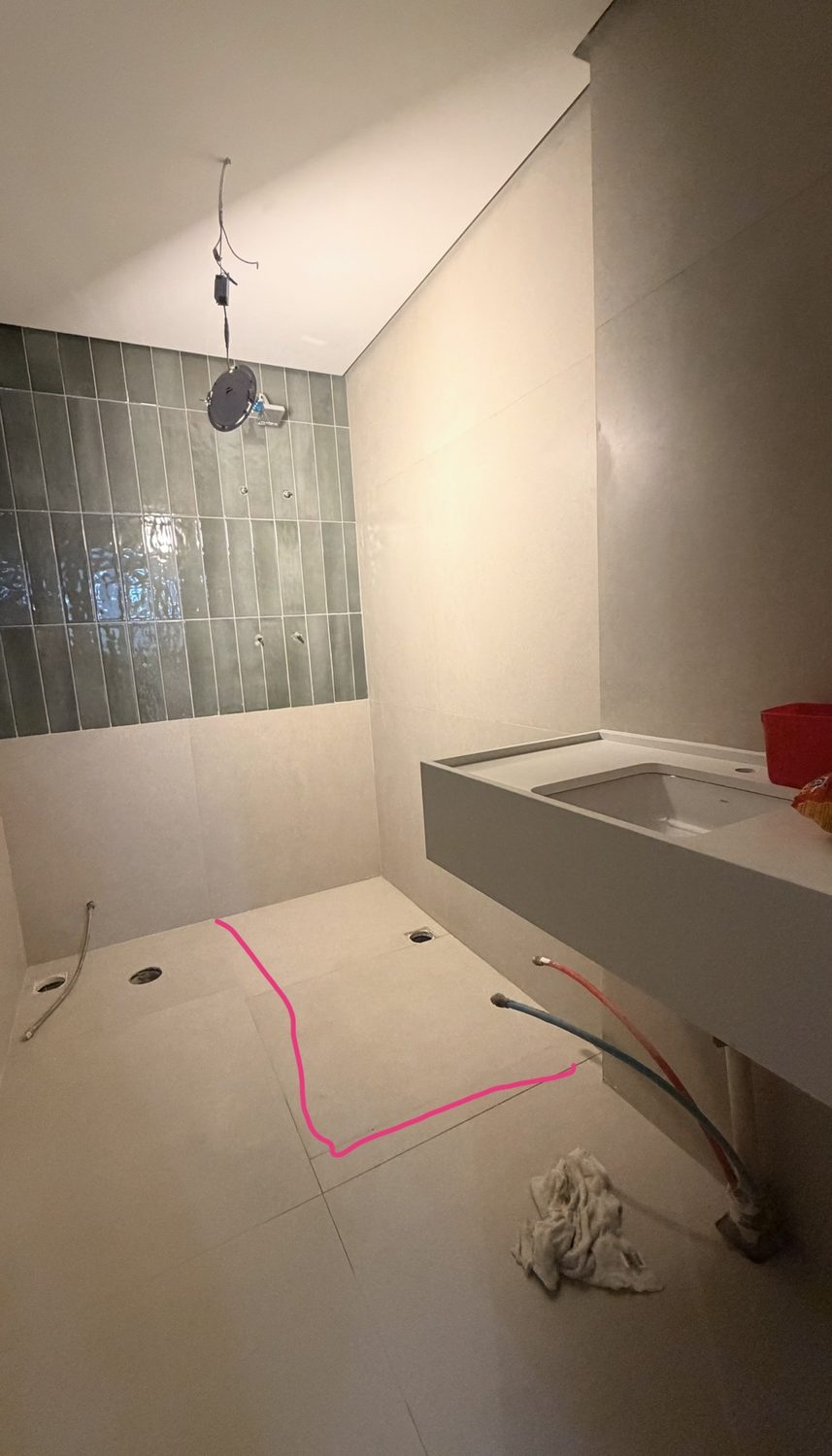 Baño con revestimiento cerámico verde vertical, porcelanato en el piso, mesada y conexiones de agua a la vista