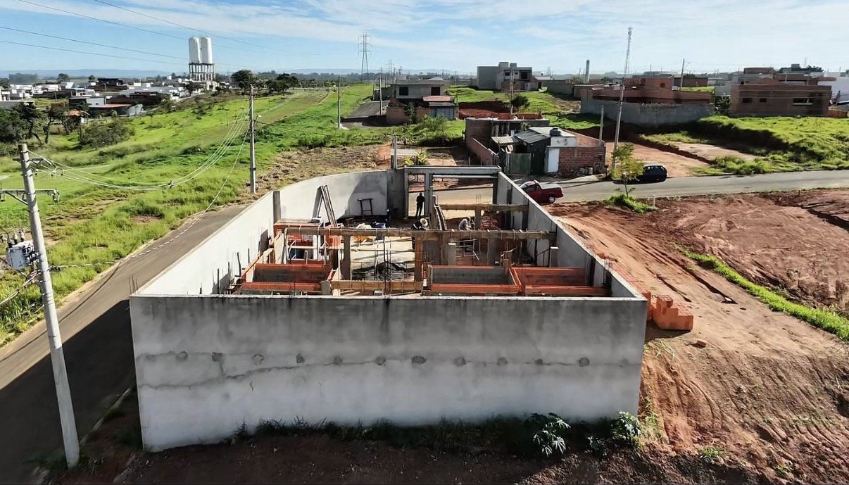 Vista aérea de la obra con el muro de contención de hormigón, encofrados y albañilería de la planta baja